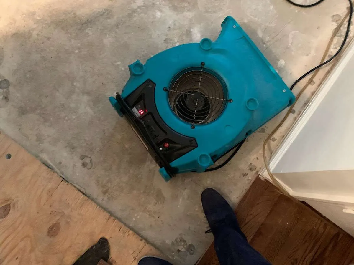 Air mover drying subfloor during Leak Detection & Repair in Waupun